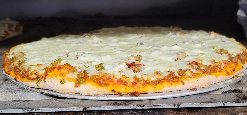 A fresh cheese pizza on a pan, straight out of the oven.